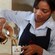 A uniformed server pours coffee from a carafe into a mug